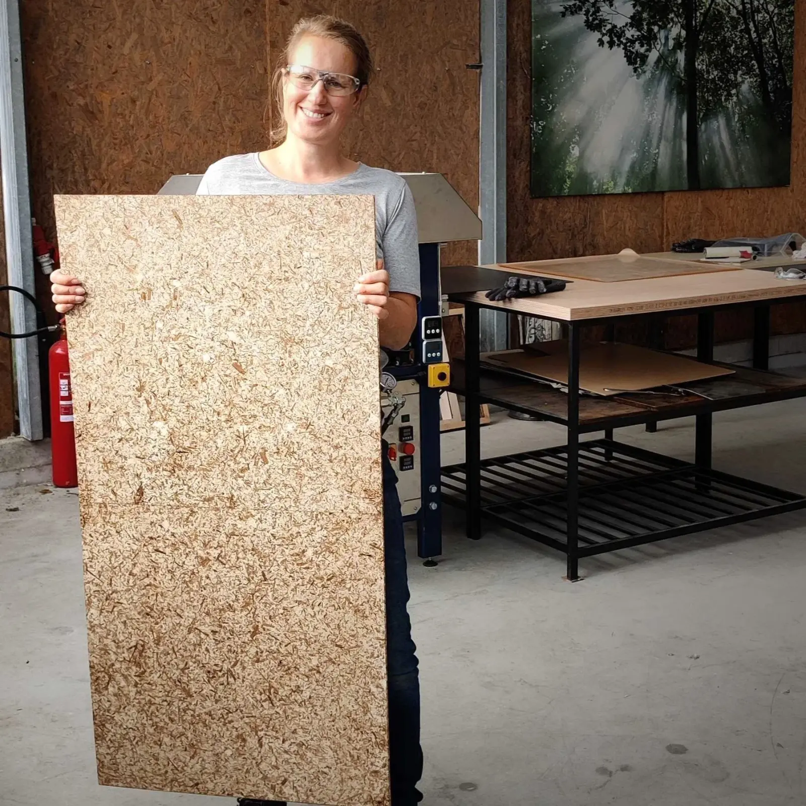 a maker holding a large BioM fibre panel in the workshop