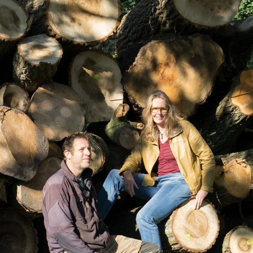 two people from Stadshout seated on a pile of logs